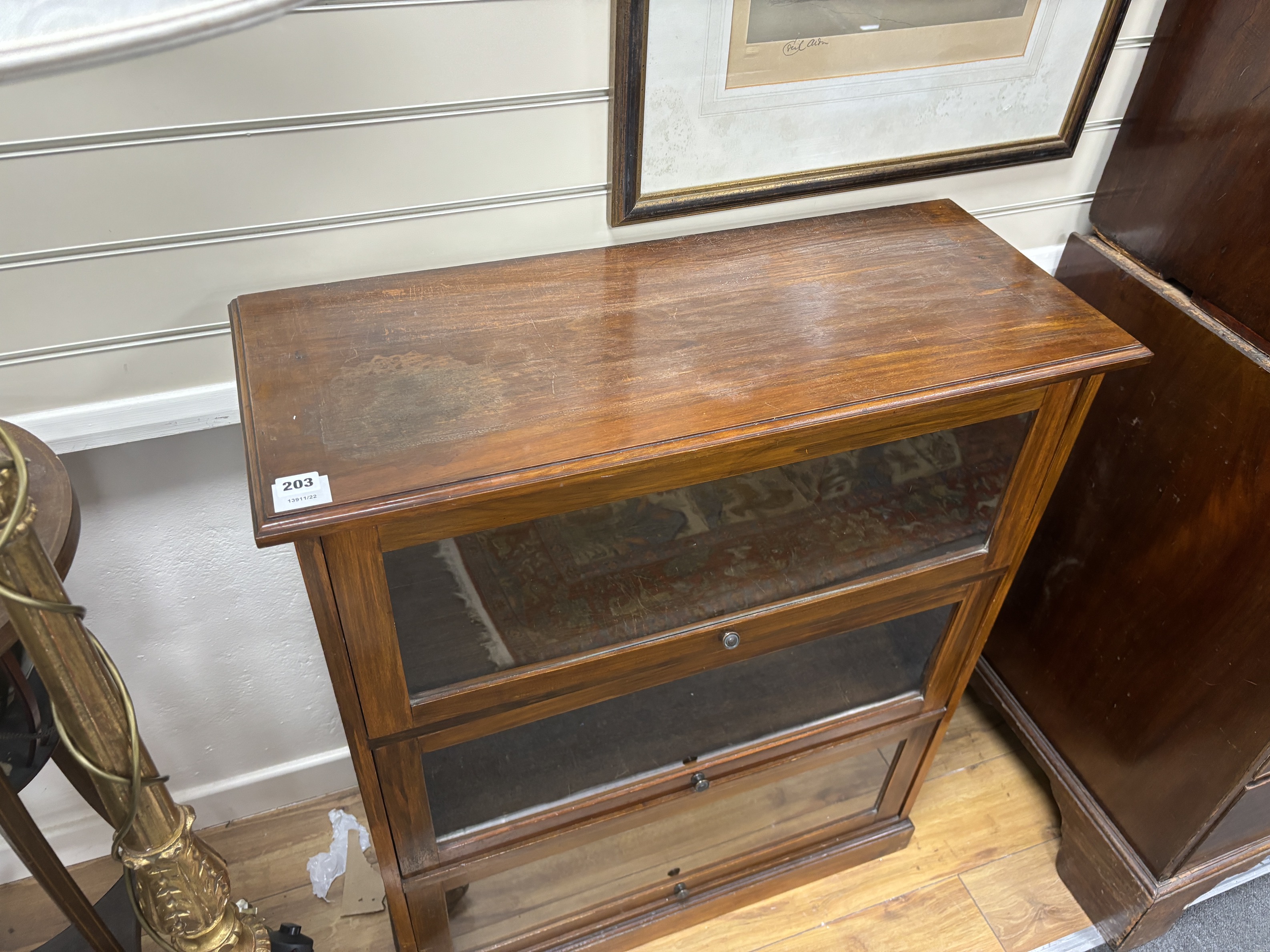 A glazed mahogany three door bookcase, width 82cm, depth 34cm, height 99cm